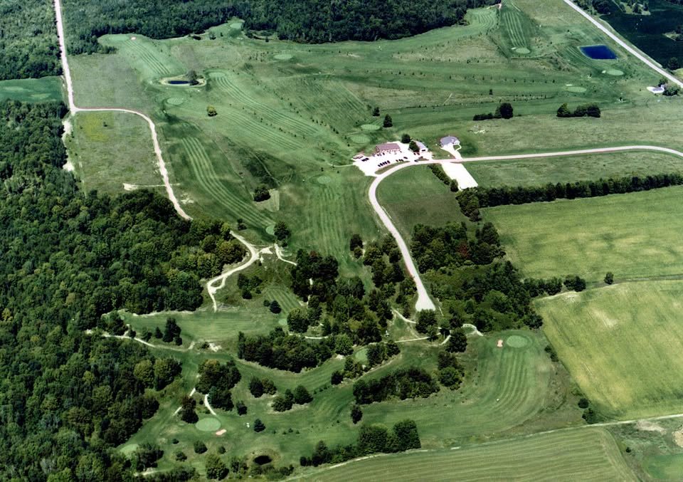 Aerial view of Parkway Golf Course, with fairways cut through woodland and farm fields and the clubhouse at the centre